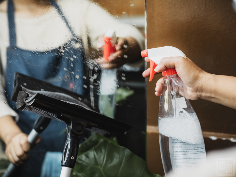 person cleaning a mirror